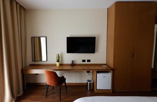 a bedroom with a desk with a television and a chair at Valza Boutique Hotel in Vlorë