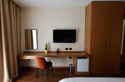 sypialnia z biurkiem, telewizorem i krzesłem w obiekcie Valza Boutique Hotel we Wlorze