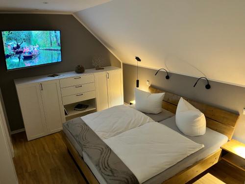 a bedroom with a bed with a tv on the wall at Zur kleinen Glocke in Burg