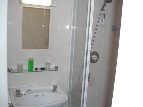 a bathroom with a sink and a shower with a mirror at Lynebank House Hotel, Bed & Breakfast in Carlisle