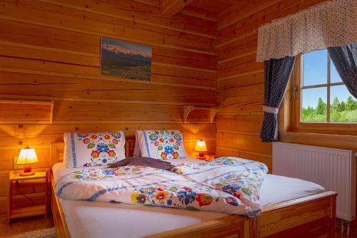 a bedroom with a bed in a log cabin at Goralské drevenice Pieniny in Červený Kláštor