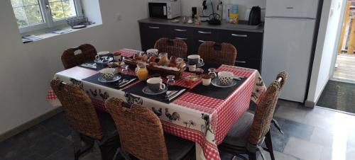 a dining room table with a red and white table cloth at La cabane in Montipouret
