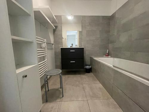 La salle de bains est pourvue d'un lavabo, d'une baignoire et d'un tabouret. dans l'établissement Mini villa K2, à Bonifacio