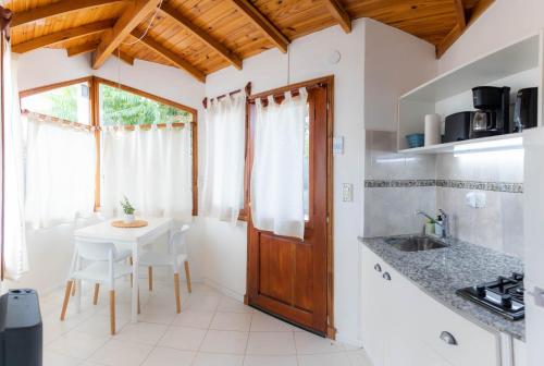 a kitchen with a table and a sink and a window at Mamma, Esquel. in Esquel