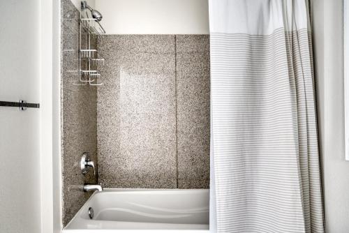 a bathroom with a tub and a shower curtain at Fremont 1BR w wd gym pool nr Tesla SFO-1123 in San Mateo