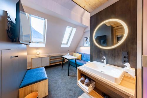 y baño con lavabo y espejo. en BOLLWERK Lifestyle Hotel, automatisiertes Hotel mit Self Check In, en Immenstadt im Allgäu