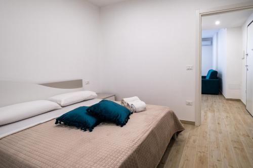a bedroom with a bed with two blue pillows on it at Dimora Idrusa in Otranto