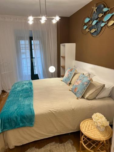 a bedroom with a large bed and a table at Apartamentos El Escudo Centro in Ribadesella
