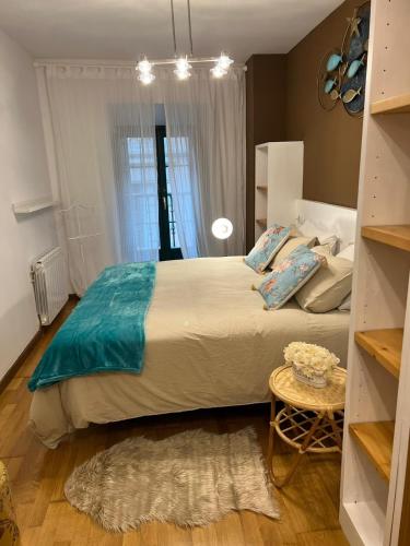 a bedroom with a large bed and a table at Apartamentos El Escudo Centro in Ribadesella