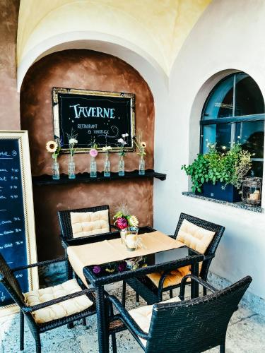 a table and chairs on a patio with a sign on the wall at Atlas Grand Hotel in Garmisch-Partenkirchen