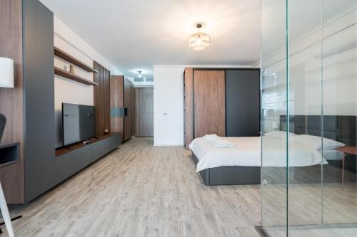 een slaapkamer met een bed en een glazen wand bij Kondo studio I Roka Residence, Timpuri Noi in Boekarest