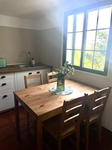 a wooden table in a kitchen with a vase with flowers on it at La Macadamia in La Laguna