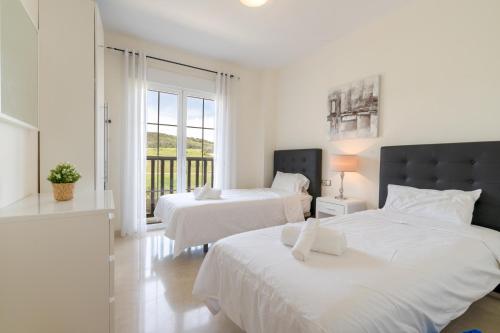 - 2 lits dans une chambre blanche avec fenêtre dans l'établissement 18 Nice apt balcony pool view close to Duquesa Golf and Beach Manilva Andalusia, à San Luis de Sabinillas