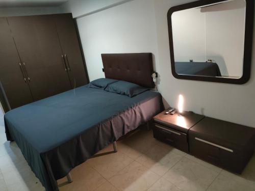 a small bedroom with a bed and a mirror at apartamento moderno in Benidorm