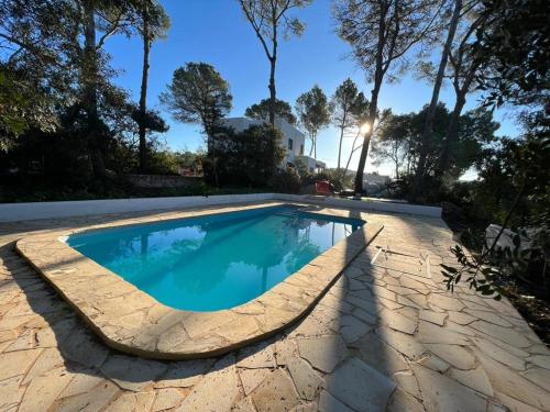 una piscina con un passaggio in pietra intorno ad essa di Spacious & Luxury villa in centre Ibiza a Santa Gertrudis de Fruitera