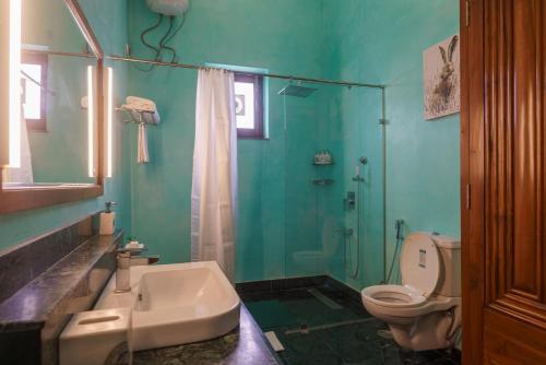 Un baño con inodoro, lavabo y ducha. en amã Stays & Trails Abhay Manor Kaali Toonk, Udaipur, en Ghānerao