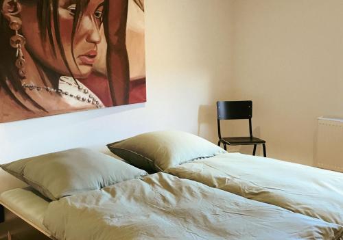ein Bett mit einem Gemälde, das an einer Wand hängt in der Unterkunft Villa Roc in Grünenbach