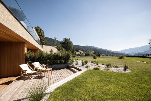 a garden with two chairs and a wooden deck at Santre dolomythic home in Bressanone