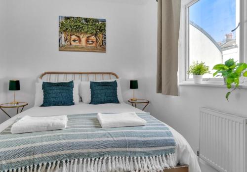 a white bedroom with a large bed with blue pillows at Golden Sunset House Free Parking By My Getaways in Brighton & Hove
