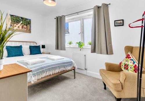 a bedroom with a bed and a chair and a window at Golden Sunset House Free Parking By My Getaways in Brighton & Hove