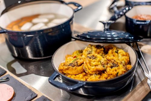 a dish of food is sitting on a stove at BOLLWERK Lifestyle Hotel, automatisiertes Hotel mit Self Check In in Immenstadt im Allgäu