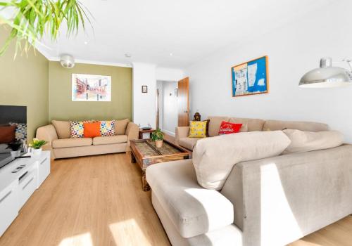 un salon avec deux canapés et une télévision dans l'établissement Golden Sunset House with free parking by My Getaways, à Brighton et Hove