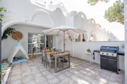 cocina con mesa y sombrilla en el patio en Casa Hibiscus Marbella, en Marbella