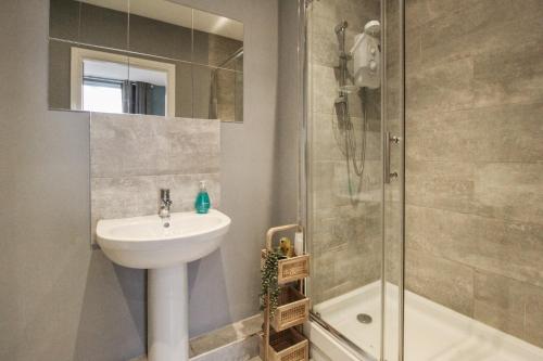 a bathroom with a sink and a shower at Sleek & Stylish Apartment in the Heart of the City in Nottingham