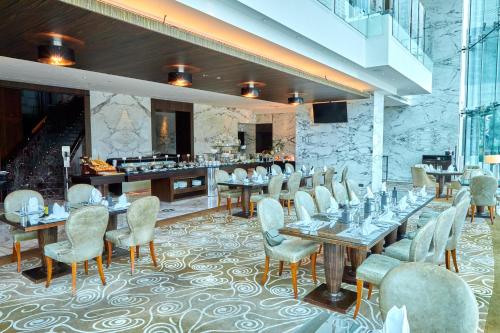 a restaurant with tables and chairs and a buffet at Lagom Vacation Homes 1 & 2 bedroom Apartment in Bonnington Tower, cluster J in Dubai
