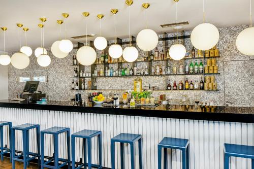 a row of blue stools at a bar with lights at Blue Orange Resort in Prague