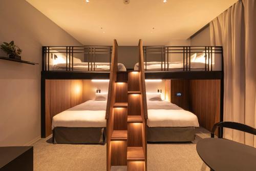 two bunk beds in a room with a table at Hotel Keihan Namba Grande in Osaka