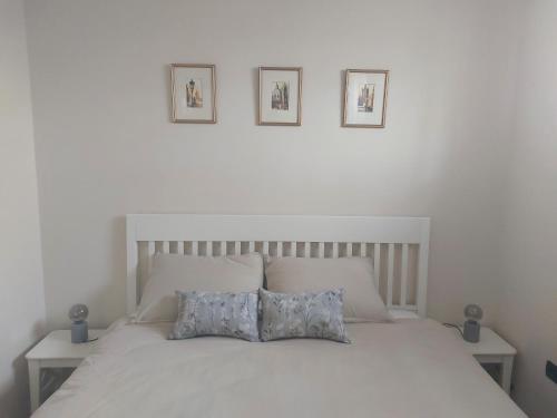 sypialnia z białym łóżkiem z 2 poduszkami w obiekcie APARTMENT KORTINE w mieście Sečovlje