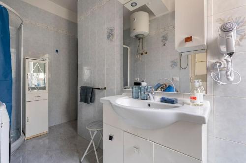 uma casa de banho branca com um lavatório e um espelho em Dedde's House em Quartu SantʼElena