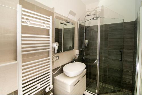 a bathroom with a toilet and a glass shower at Hotel Saligari in Verceia