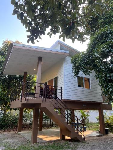 a house with a staircase leading up to it at Naisang Hostel in Chumphon