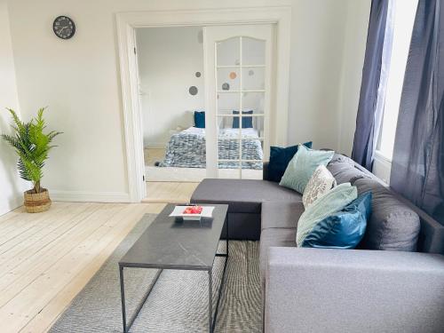 a living room with a couch and a table at aday - Beautiful 2 bedrooms apartment in the heart of Frederikshavn in Frederikshavn