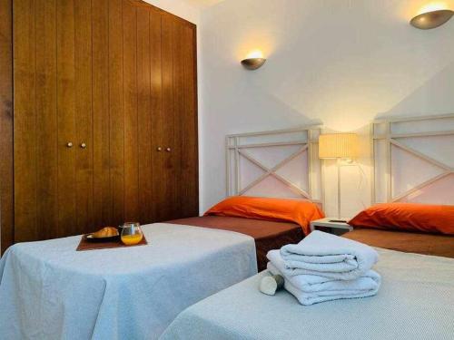 - une chambre avec 2 lits et des serviettes dans l'établissement Magnífico apartamento a 500 m de la playa, à Alicante