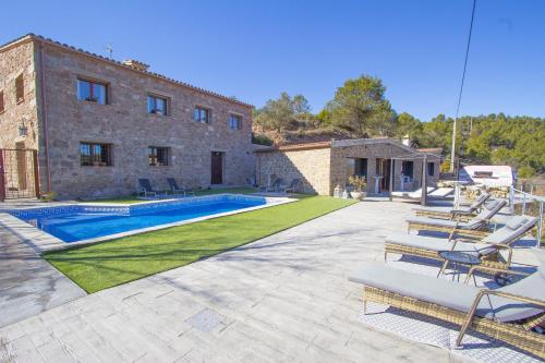 a villa with a swimming pool in front of a building at Vila Caelus masía boutique in Rubio