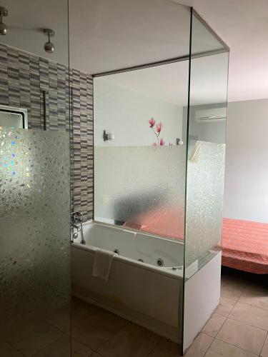 a bathroom with a glass shower with a bath tub at Hostal - Restaurante Asador Esperanza in Huesca