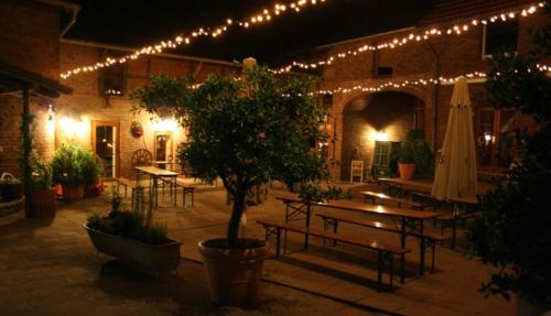 einen Innenhof mit Tischen, einem Baum und Lichtern in der Unterkunft McMüller's Brauereigasthof in Kofferen