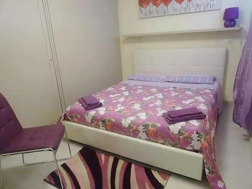 a small bedroom with a bed and a chair at Glicine Apartment in Gallipoli