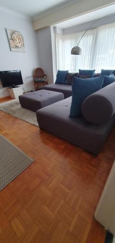 Sala de estar con 2 sofás y TV en Cosy apartment near the beach and city center, en Ostende