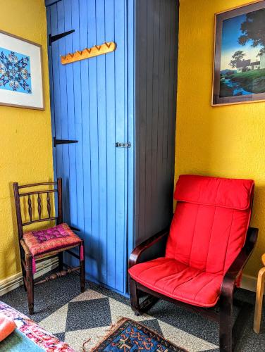 a red chair sitting next to a blue door at 6 Park Terrace in Glastonbury