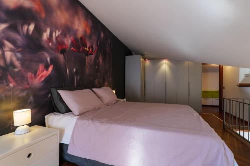 a bedroom with a bed with a painting on the wall at Residenza Ticino in Verbania