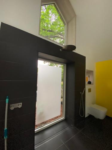 La salle de bains est pourvue d'une fenêtre et de toilettes blanches. dans l'établissement Oak Cottage near Rønne & Beach, à Rønne