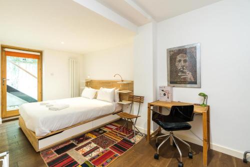 ロンドンにあるCharming 2 Bedroom Apartment in Kentish Townのベッドルーム1室(ベッド1台、デスク、椅子付)
