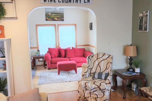 a living room with a red couch and a chair at A Wine Country Home in Yamhill County in Lafayette