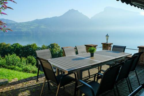 a table with chairs and a view of the water at Villa Nora in Faulensee