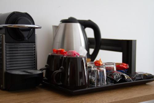 un vassoio con tazze e una caffettiera sul tavolo di Michelangelo Vatican Rooms a Roma