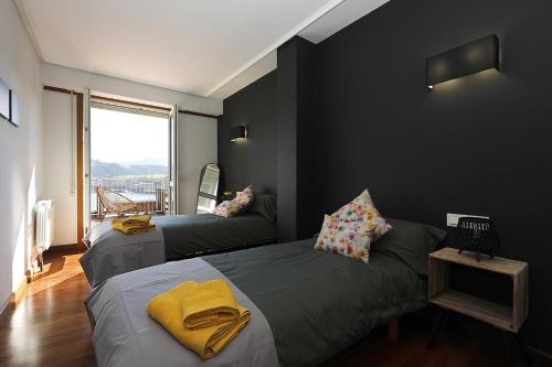 1 dormitorio con 2 camas y ventana en Xatetto Etxea Ocean View, en Zumaia